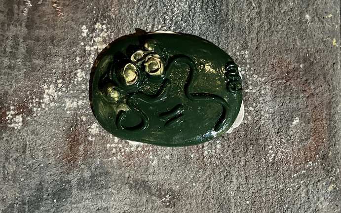A green glazed 5=3 plaque set into a stone wall in Vienna.